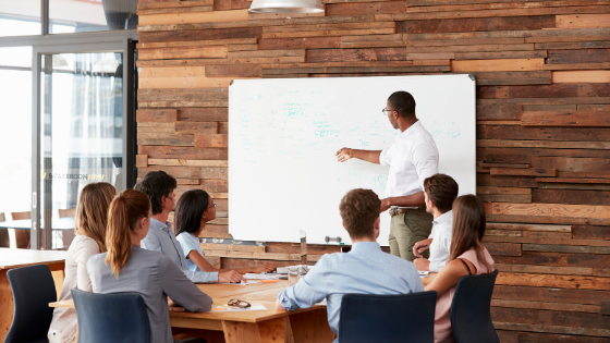 Man Pointing At White Board In Business Meeting